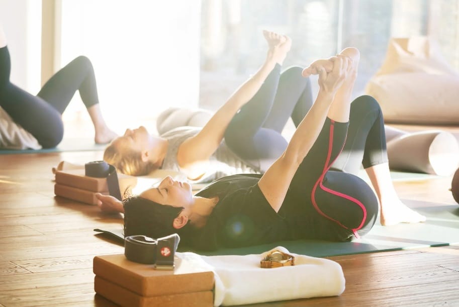 Women practicing yoga in a bright studio